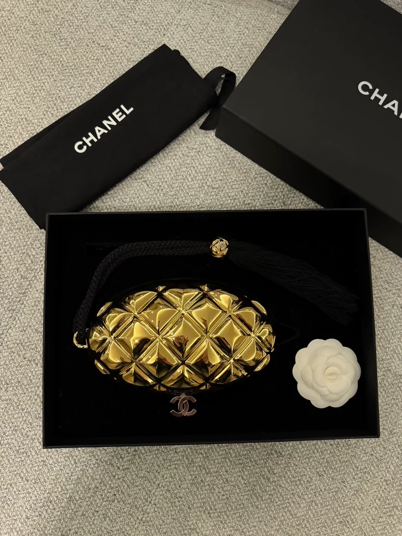 Chanel 26P gold oval evening clutch featuring the signature diamond quilting and a tassel adornment